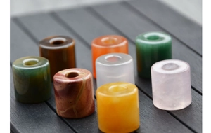 Macro shot of colorful cylindrical gemstone beads on dark wood background for DIY jewelry