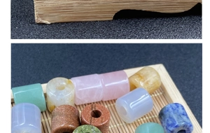 Macro view of polished cylindrical natural stone beads in a bamboo tray for jewelry making
