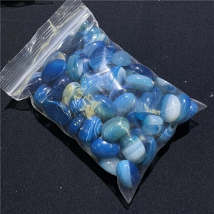 Macro detail of blue lace agate oval stones with natural stripes in a transparent bag
