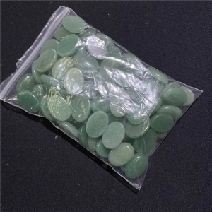 Close-up of polished green agate oval stone beads for DIY jewelry making in a plastic bag