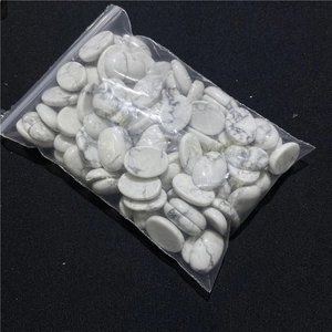 Macro detail of oval white howlite stones with grey veins in a clear plastic bag