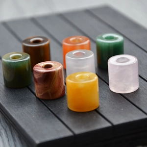Polished cylindrical natural stone loose beads for DIY jewelry making on wooden plate