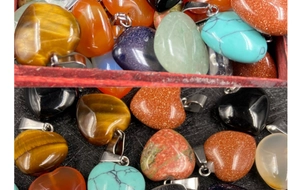 Dettaglio di ciondoli a forma di cuore in pietre diverse con ganci in metallo argento