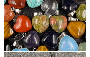 Dettaglio di ciondoli a cuore in diverse pietre naturali e colori con gancio in metallo
