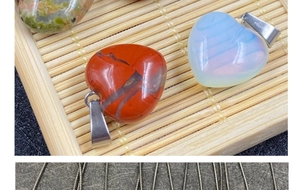 Vista macro di ciondoli a forma di cuore in pietre diverse su un tappetino di bambù