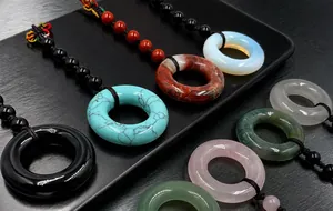 Macro detail of various natural gemstone pendant rings with hand-woven cord straps