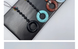 Close-up of various natural stone pendants with colorful handmade woven knots on display