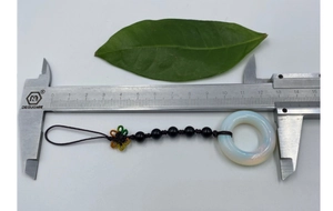 Detail of woven gemstone pendant with white opal ring and black beads showing 12cm length