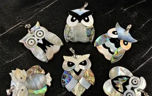 Detail showing owl pendants made of natural abalone shell with shimmering rainbow luster
