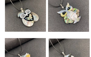 Macro shot of owl pendants made with shimmering abalone and white shell inlay