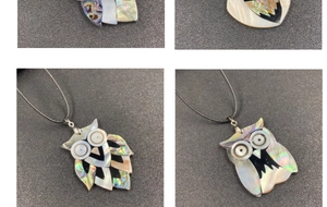 Detailed view of handmade owl pendant crafted with iridescent abalone and white shell inlay