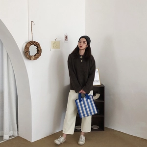 Blue and white checkered tote bag styled with casual autumn knitwear and trousers