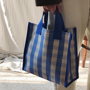Blue and white striped canvas tote bag with woven handles for stylish daily commute