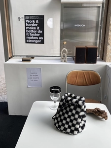 Détail du sac seau en peluche à damier avec fourrure douce et fine bandoulière noire