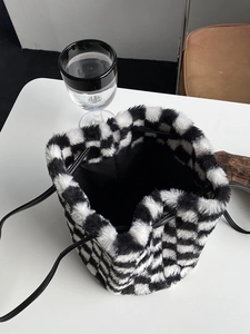 Vue de dessus du sac seau en peluche à damier avec texture douce et intérieur à cordon