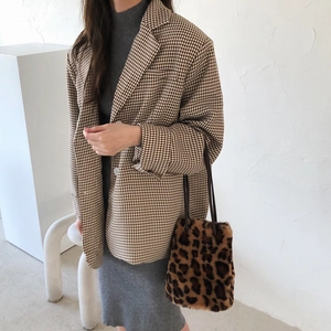 Sac seau chic en fausse fourrure léopard porté avec un blazer marron à carreaux