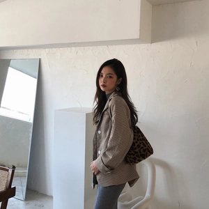 Détail d'un blazer à carreaux marron avec un sac seau en peluche à imprimé léopard chic