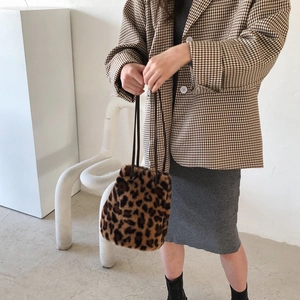 Sac seau en fausse fourrure léopard porté à l'épaule avec cordon en cuir chic