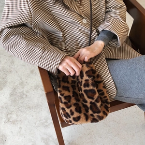 Détail du sac seau en peluche à motif léopard avec longue bandoulière marron