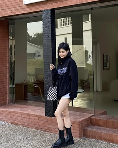 Détail d'un sweat à col zippé noir avec logo SINE et coupe streetwear décontractée