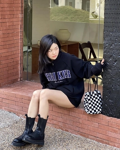 Vue extérieure d'un sac seau en peluche à damier avec un sweat-shirt noir décontracté