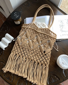 Detailed texture of handmade bohemian woven tote bag with long tassels and drawstring bag