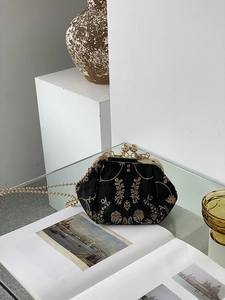 Detail of vintage kiss-lock bag with gold floral embroidery and metallic chain strap