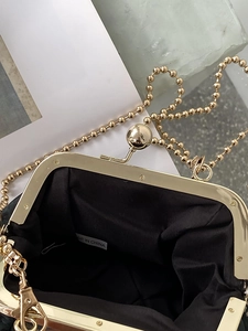 Close-up of vintage kiss-lock purse interior with gold metal frame and bead chain