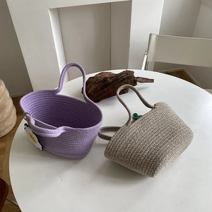 Detail of hand-woven cotton rope tote bags in purple and oat colors with cute charms