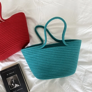 Detail of hand-woven turquoise cotton rope tote bag with stripe texture and soft handles