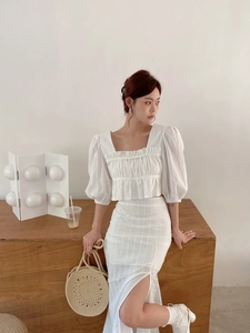 Détail de l'ensemble deux pièces blanc avec manches bouffantes et jupe fendue taille haute