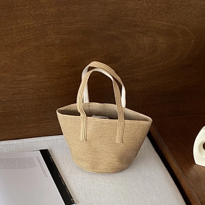 Handcrafted straw tote bag with spiral woven pattern and dual handles for summer beach use