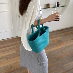Detailed texture of peacock blue woven tote bag with cotton rope craft and handle