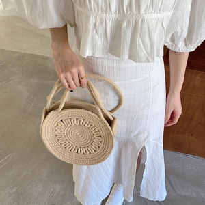 Détail du sac en paille tressé à la main avec textures en spirale et motifs ondulés pour l'été
