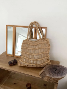 Detail of hand-woven beige cotton rope tote bag showing intricate knot texture and lining