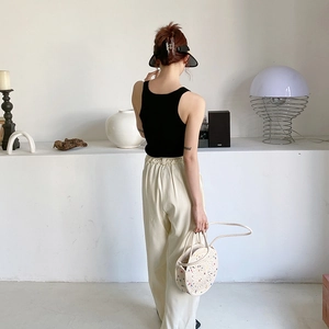 Vue arrière d'une tenue d'été avec débardeur noir et pantalon large blanc cassé