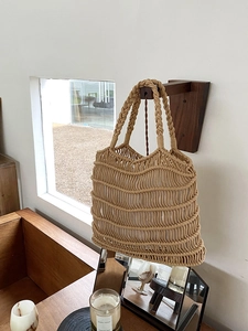 Detail of handmade khaki macrame tote bag featuring intricate wave knit texture and sturdy handles