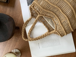 Macro shot of handcrafted hollow woven mesh tote bag with beige cotton inner lining