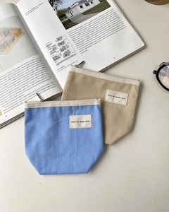 Flat lay of canvas storage pouches in blue and khaki with minimalist chic labels