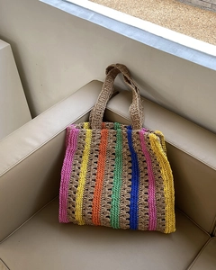 Close-up of vibrant colorful striped texture on handmade straw woven tote bag