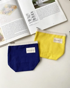 Detail view of durable canvas pouches in blue and yellow with metal zipper closure