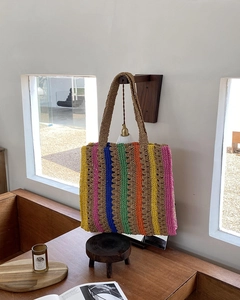 Macro view of multi-color striped handmade woven straw tote bag texture and handles