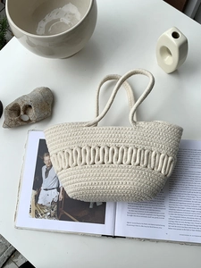 Detail of off-white cotton rope woven handbag with unique 3D wave texture on a table