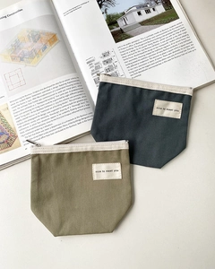 Detailed canvas zipper pouches in olive and dark blue with nice to meet you woven labels
