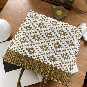 Large woven beach tote with white and gold geometric patterns and circular handles
