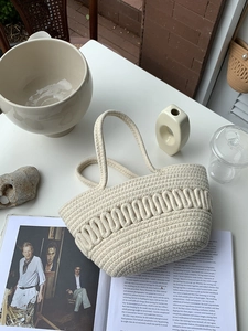 Detailed weave of a cream cotton rope handbag on a minimalist artistic background