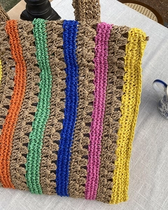 Detailed close-up of handmade woven straw tote with vibrant multi-color stripes