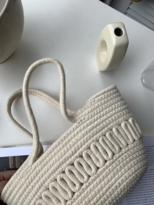Detail of cream cotton rope woven tote bag with bohemian U-shaped texture and handles