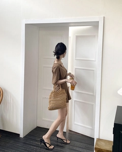 Minimalist summer outfit featuring a brown cotton dress and hollow woven straw tote bag