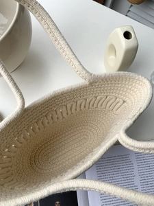 Close-up of cream woven tote bag showing intricate cotton rope texture and interior